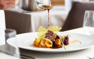 a plate of food on a table with a spoon at Hanusel Hof Wellness & Genuss in Panoramalage in Hellengerst