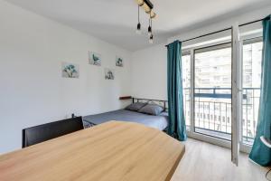 a bedroom with a bed and a large window at Le Casual- Clichy in Clichy