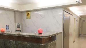 un baño con una encimera con bolas rojas. en Ji Pin Hotel, en Xinzhuang