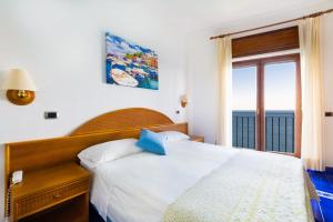 a bedroom with a bed with a view of the ocean at Hotel Sporting in Vico Equense