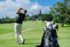 un hombre balanceando un club de golf en un campo de golf en San Lameer Villa - 14306 - 5 Bedroom Luxury - 10 pax - San Lameer Rental Agency, en Southbroom