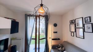 sala de estar con sofá y lámpara colgante en ICONN House Garden, en Vimodrone