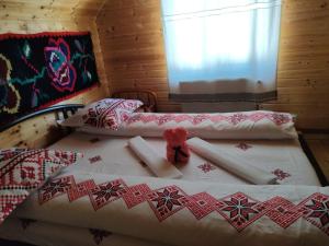 a bedroom with a bed with a teddy bear on it at Cabanele Rus in Budeşti