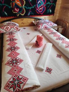 Una cama con almohadas rojas y blancas. en Cabanele Rus en Budeşti