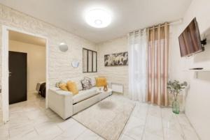 salon z białą kanapą i telewizorem w obiekcie Le cosy DisneyLand Paris w mieście Montévrain