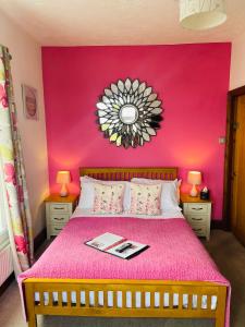 a bedroom with a pink wall with a bed and a mirror at The Railway Inn in Rise
