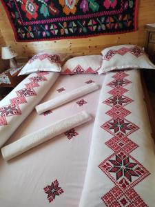 ein Bett mit Weihnachtskissen darüber in der Unterkunft Cabanele Rus in Budeşti