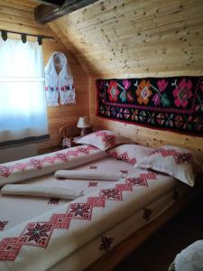 BudeştiにあるCabanele Rusのログキャビン内のベッドルーム1室(ベッド2台付)