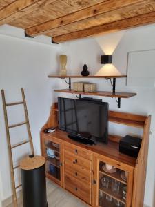 a living room with a television on a wooden cabinet at Lovely House at Oia Village Center in Oia