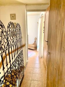 - un couloir avec une porte en fer forgé dans une maison dans l'établissement Coquette maison de village pour 4 pers, à Quinson