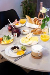a table with plates of breakfast foods and glasses of orange juice at Altstadthotel Wetzel in Mühldorf