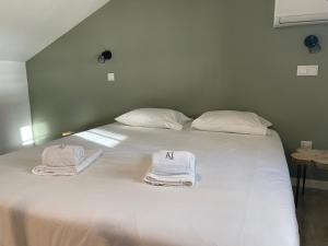two towels are sitting on a white bed at Casa Jardim By Alojamento Ideal in Porto