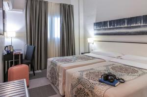 Postel nebo postele na pokoji v ubytování Hotel Macià Plaza