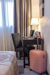 a hotel room with a desk with a laptop and a suitcase at Hotel Macià Plaza in Granada