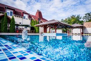a swimming pool in front of a house at Liza Aqua & Conference Hotel in Lajosmizse