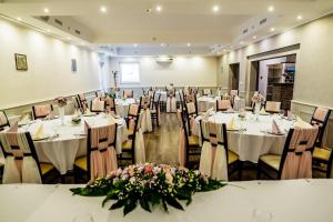 a banquet hall with tables and chairs with flowers at Liza Aqua & Conference Hotel in Lajosmizse