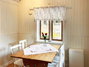 - une table à manger avec un vase de fleurs dans l'établissement Holiday home ESKILSTUNA V, à Malmköping