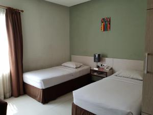 a hotel room with two beds and a window at N3 Zainul Arifin Hotel in Jakarta