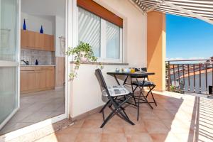 a balcony with a table and chairs and a kitchen at BANKO APARTMENTS & Rooms in Rovinj