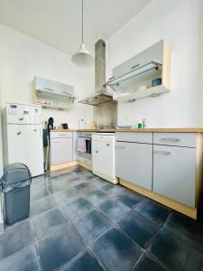 a kitchen with white cabinets and a tile floor at Down-Town 1 Bedroom Flat in Brussels