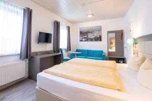 ein Hotelzimmer mit einem Bett und einem Stuhl in der Unterkunft Familien- und Aparthotel Strandhof in Tossens