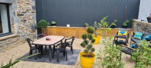 a patio with a table and chairs and potted plants at Gîte de l'Aff in La Gacilly