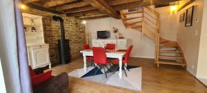 a kitchen and dining room with a table and red chairs at Gîte de l'Aff in La Gacilly