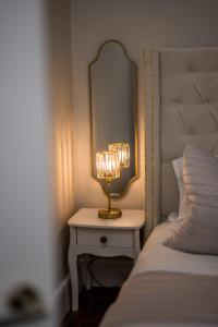 a lamp on a table next to a bed at Casa Fresa - Taymouth House in Broughty Ferry