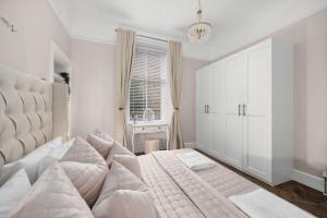 um quarto branco com uma cama grande e uma janela em Casa Fresa - Taymouth House em Broughty Ferry