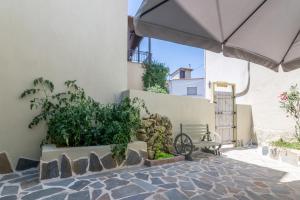 a patio with an umbrella and a bike next to a building at Goutadika in Limenas