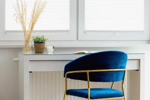 niebieskie krzesło siedzące przed biurkiem w obiekcie Fredry 6 Apartment Premium Łagiewniki by Renters Prestige w Krakowie