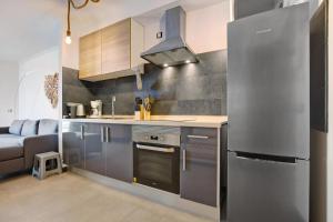 a kitchen with a stainless steel refrigerator and a couch at Casamar2197 in Cotillo
