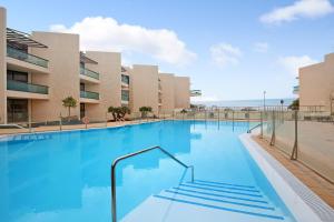 a large swimming pool in front of a building at Casamar2197 in Cotillo