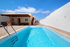 a swimming pool in front of a house at Casa Vieja in Puerto del Rosario