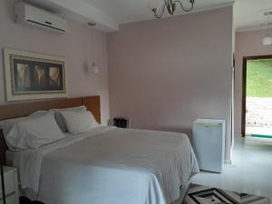 um quarto com uma cama branca e uma janela em Canto de Roca Turismo e Lazer em Mimoso do Sul