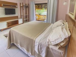 een slaapkamer met een groot bed en een televisie bij Canto de Roca Turismo e Lazer in Mimoso do Sul