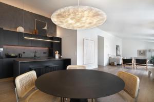 a kitchen and dining room with a black table and chairs at Villa Sofia Cascais in Cascais
