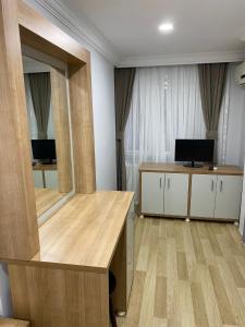 een kamer met een spiegel, een bureau en een televisie bij Kafkas Hotel Istanbul in Istanbul