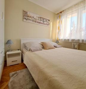 Un dormitorio con una cama grande y una ventana en Mokka Apartament, en Kielce