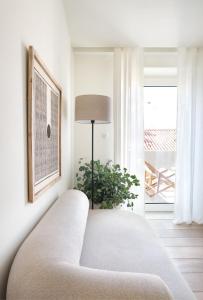 a white couch in a living room with a plant at Villa Sofia Cascais in Cascais