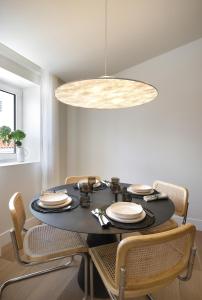 a dining room with a black table and chairs at Villa Sofia Cascais in Cascais
