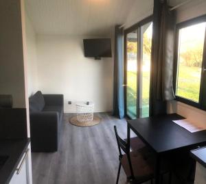 a small living room with a table and a chair at Le clos de Launay in Souvigné