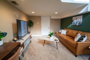 a living room with a couch and a tv at Cozy Townhouse Downtown w/ Game Room & Rooftop in Baltimore