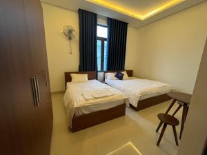 Habitación de hotel con 2 camas y ventana en Nhà Nghỉ Ánh Dương, en Quảng Ngãi