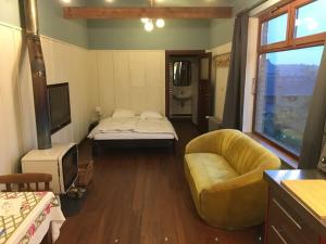 um quarto com uma cama, um sofá e uma televisão em ziggy's room with a view em Heyd