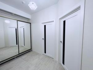 an empty room with two mirrors and white walls at Lovely apartment with terrace in Chişinău