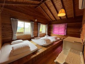 Habitación con 2 camas en una cabaña de madera en Wen Qiao Villa en Nanzhuang
