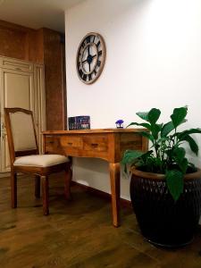 a desk with a chair and a plant and a clock at Flowers in the attic in Żywiec