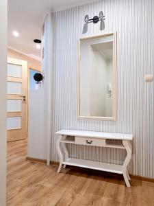 a bathroom with a white vanity and a mirror at Mokka Apartament in Kielce