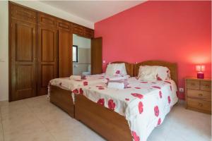 a bedroom with a large bed with a red wall at Villa Alegria in Loulé +15 photos